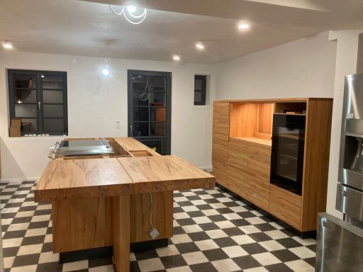 Moderne Küche mit Holzregalen, Schachbrettmusterboden und hellem Licht.